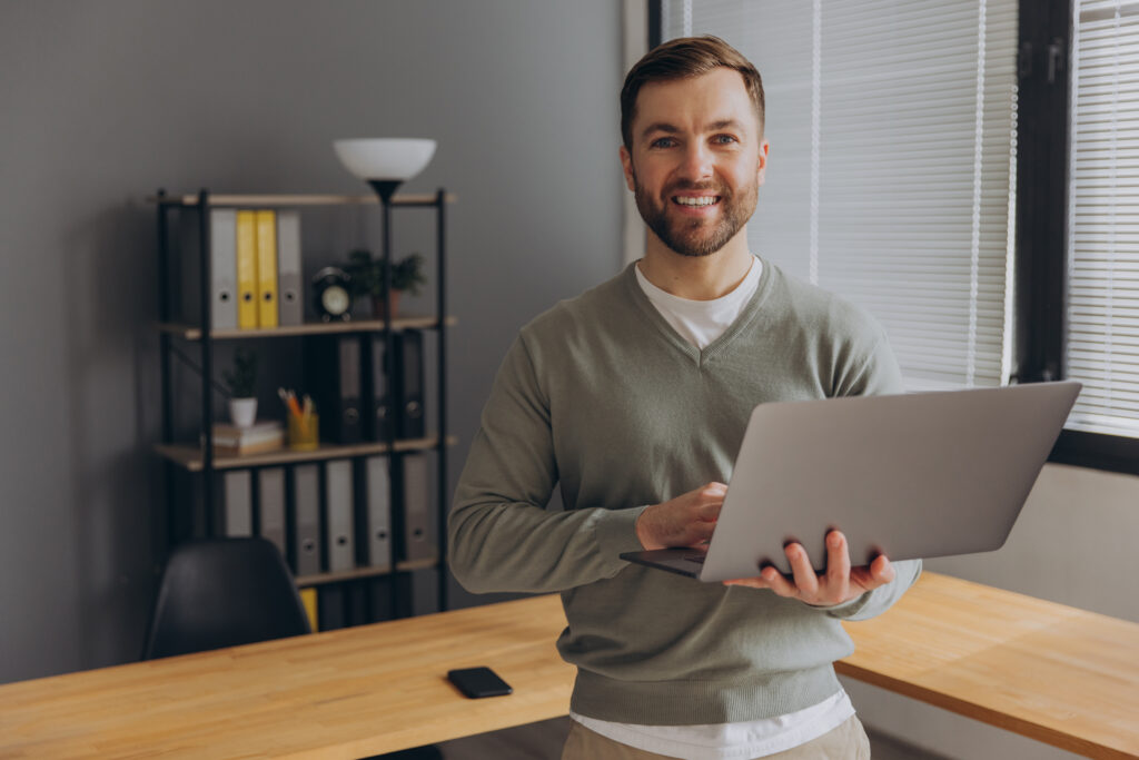 Modern happy bearded office male worker of IT company smiling an